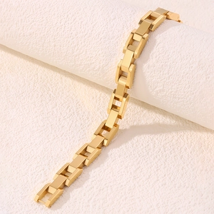 Vue détaillée d'un bracelet en acier titane plaqué or avec maillons en forme de H