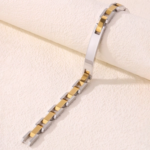 Détail du bracelet en acier bicolore avec maillons imbriqués et plaque centrale polie