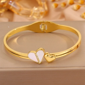 Détail d'un bracelet doré 18 carats avec cœurs, cristaux et incrustation en nacre blanche