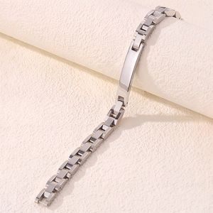 Vue macro détaillée du bracelet à maillons en acier inoxydable argenté avec plaque courbée
