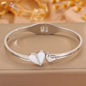 Détail macro du bracelet cœur argenté avec nacre et accents de pavé de cristaux