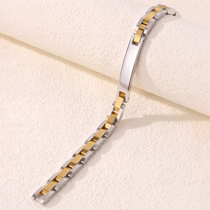 Gros plan du bracelet ID bicolore en acier inoxydable or et argent avec plaque de métal poli