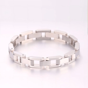 Gros plan détaillé sur les maillons géométriques industriels d'un bracelet en acier argenté