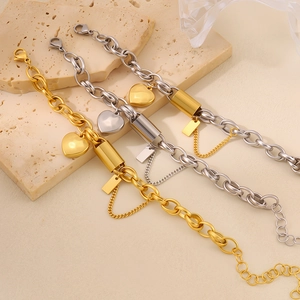 Elegant 18K gold and silver heart pendant bracelets set on a textured stone surface
