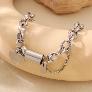 Detail shot of heavy link silver stainless steel bracelet with heart charm and pendant