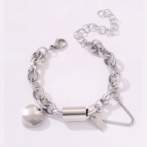 Detail of chunky stainless steel heart charm bracelet with engraved tag and lobster clasp