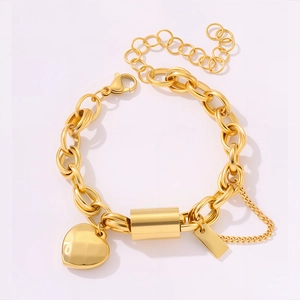 Detail of gold heart pendant and thick chain links of the stainless steel bracelet