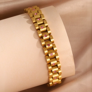 Detalle de pulsera dorada estilo reloj con cristales rosas sobre fondo de seda suave