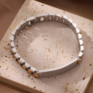 Detalle de pulsera de titanio con cristales rosas y placa de identificación plateada