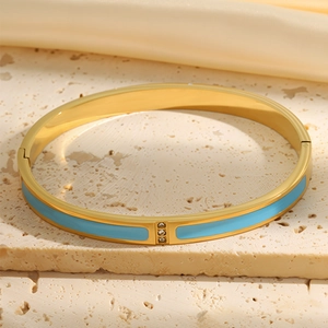 Detail of 18k gold plated bangle with light blue enamel and three diamond accents