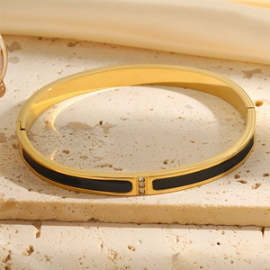 Macro detail of 18k gold plated stainless steel bangle with three diamonds and enamel inlay