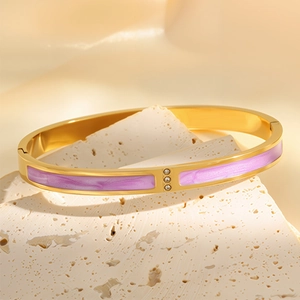 Detail of 18k gold plated stainless steel bangle with purple enamel and three zircons