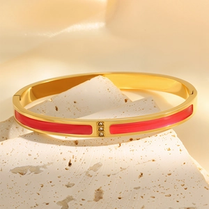 Macro view of 18k gold plated stainless steel bangle with red enamel and triple crystals