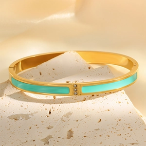 Detail of 18k gold plated bangle with mint green enamel and three inset zircons