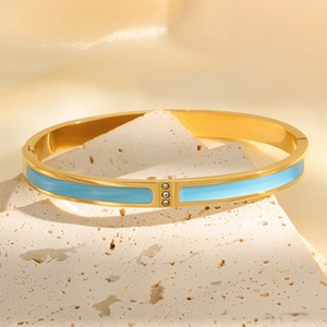 Detailed close-up of 18k gold plated bangle with light blue enamel and three zircon stones