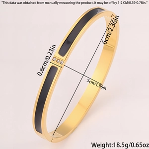 Detail of 18k gold plated bangle with black enamel inlay and three small zircons