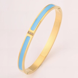 Detail of 18k gold plated stainless steel bangle with blue enamel and three zircon stones