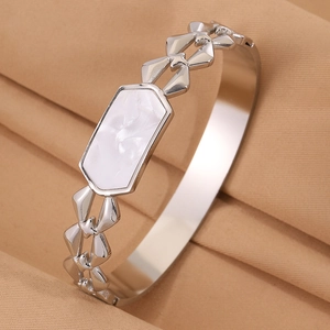 Detalle del brazalete plateado geométrico calado con incrustación de nácar blanco