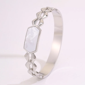 Detalle macro de la pulsera geométrica plateada con mármol blanco y rombos tallados