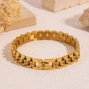Detail of golden stainless steel watch-style bracelet with dark grey flower patterns