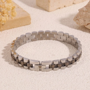 Detailed macro view of silver steel link bracelet featuring engraved floral pattern accents