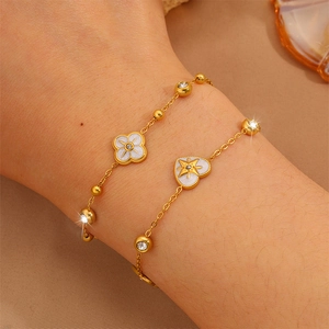 Elegantes Gold-Titan-Armband-Set mit Kleeblatt- und Herzanhängern und funkelnden Kristallen