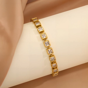 Detailed close-up of golden link bracelet featuring square-cut sparkling zircon stones