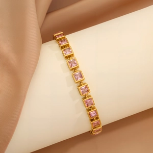 Detail of elegant gold bracelet featuring square links with pink zircon gemstones on display