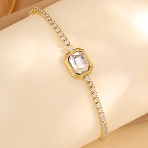 Détail macro du bracelet doré avec cristal rectangulaire et pavage de diamants blancs