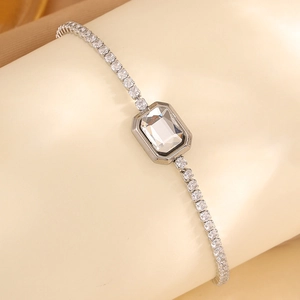 Détail d'un bracelet en acier titane argenté avec cristal rectangulaire et chaîne tennis