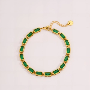 Detail of gold stainless steel bracelet with rectangular green emerald zircons and lobster clasp