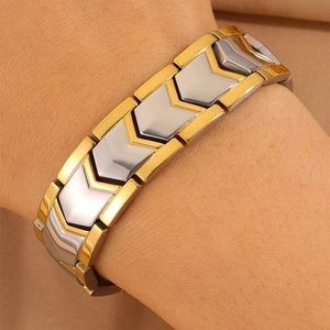 Detail of two-tone stainless steel bracelet with V-shaped links on a person's wrist