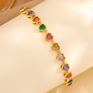 Detailed close-up of a gold heart-shaped rainbow zircon bracelet on a curved display stand