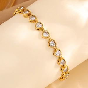 Close-up of gold heart bracelet featuring sparkling heart-shaped zircon stones