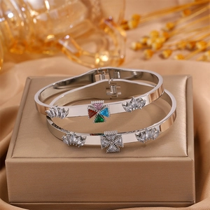 Detailed close-up of tree of life bangles with colorful gemstones on a gold silk background