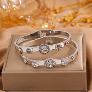 Polished silver stainless steel tree of life bangles with colorful rhinestones on a stand