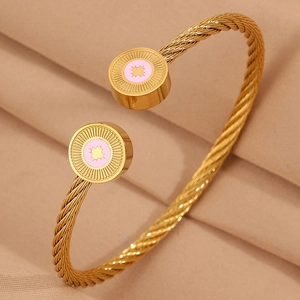 Détail du bracelet câble doré avec médaillons en émail rose et étoile octogonale