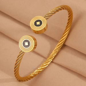 Détail du bracelet jonc doré à câble torsadé avec motif étoile et disque noir poli