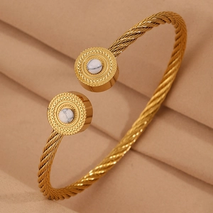 Détail du bracelet torsadé doré avec incrustation de pierre marbrée aux extrémités