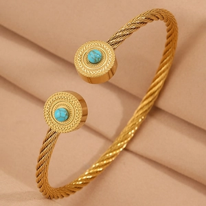 Détail macro du bracelet câble doré avec incrustation de turquoise et embouts gravés