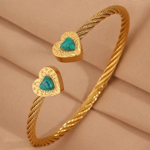 Detail view of gold twisted cable bracelet with heart-shaped turquoise and sunray engraving