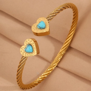Detailed close-up of golden cable wire bracelet with heart charms and turquoise inlays