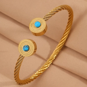 Détail macro du bracelet câble doré avec pierres turquoise bleues et fini torsadé