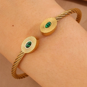 Détail du bracelet torsadé plaqué or orné de deux pierres de malachite ovales vertes