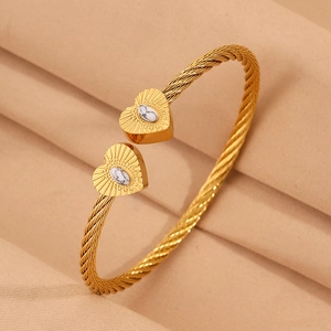 Detail of twisted gold wire bracelet featuring heart-shaped ends with marble stone inlay