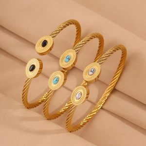 Détail de trois bracelets câbles plaqués or 18 carats avec incrustations de pierres