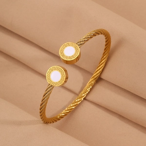 Vue détaillée du bracelet en câble doré avec motif grec et incrustation blanche ronde