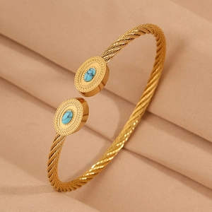Vue détaillée d'un bracelet câble doré avec extrémités ovales et incrustations de turquoise