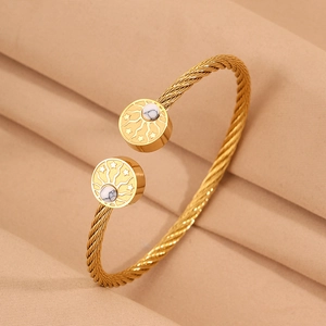 Détail macro du bracelet câble doré avec incrustation marbre et motifs soleil étoile