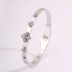 Detailed close-up of a stainless steel clover bracelet with sparkling zircon accents